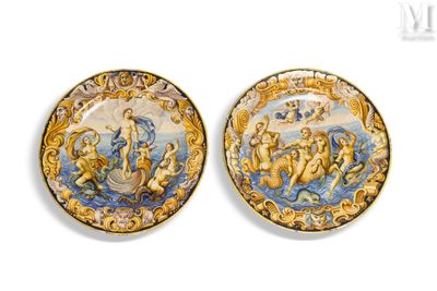 two decorative plates with figures on them on a white surface