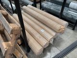 de nombreux rouleaux de bois posés à même le sol dans un entrepôt