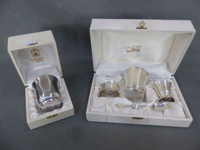 two silver cups in a white box on a table