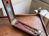 a wooden desk with a mirror and a clock on top of it