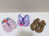 trois paires de chaussures d'enfants posées sur une table