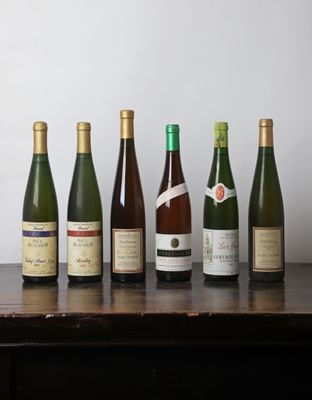 plusieurs bouteilles de vin sont alignées sur une table en bois