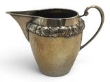 a silver pitcher that is sitting on a white surface