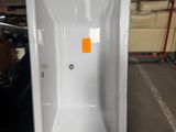 une baignoire blanche posée sur une palette dans un entrepôt