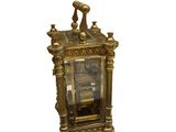 a gold clock with a bird on top of it