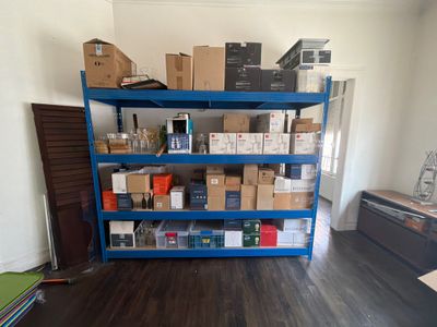 a blue shelving with many boxes on it in a room