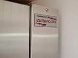 a silver refrigerator with a cardboard box on top of it