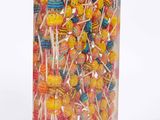 brightly colored lollipops in a clear box on a white background