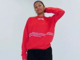 une femme vêtue d'un sweat-shirt rouge et d'un pantalon noir