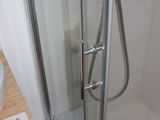 a shower with a glass door next to a sink and a toilet