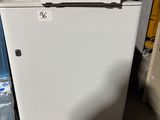 a small white refrigerator in the corner of a room