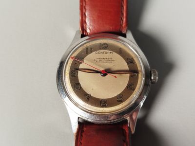 a close up of a wrist watch on a white surface