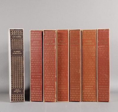 Plusieurs livres sont alignés sur une étagère à côté d'une télécommande