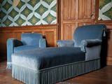 un canapé bleu et un fauteuil bleu dans une pièce aux murs lambrissés
