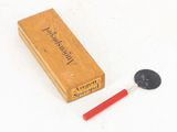 a small wooden box with a red handle next to a black button