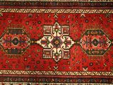 an oriental rug with red and blue designs on a white background