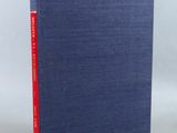 a blue book sitting on top of a table next to a white wall
