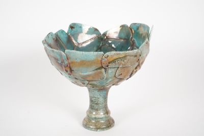 a blue bowl with a bird on it on a white surface
