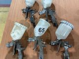 many spray guns sitting on a table in a room