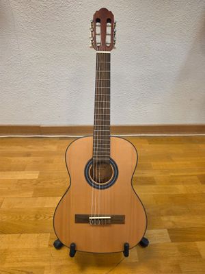 a close up of a guitar on a stand on a wooden floor