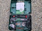 une boîte verte contenant des outils, posée par terre