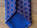 a close up of a tie on a table with a wooden surface