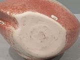 a red and white vase sitting on a table