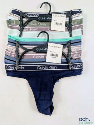 three pairs of underwear are hanging on a hanger on a wall