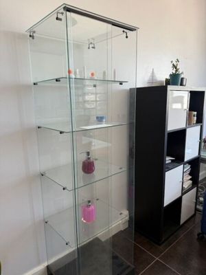 une vitrine en verre dans le coin d'une pièce
