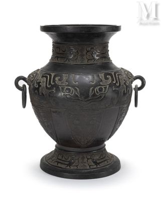 un vase noir muni d'anses sur fond blanc