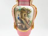 a pink vase with a picture of a peacock on it