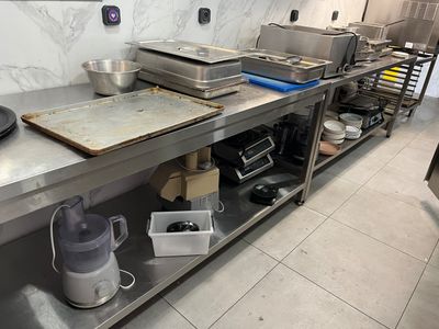 une cuisine avec de nombreux plans de travail en inox