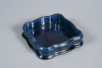 a small blue square dish on a white table