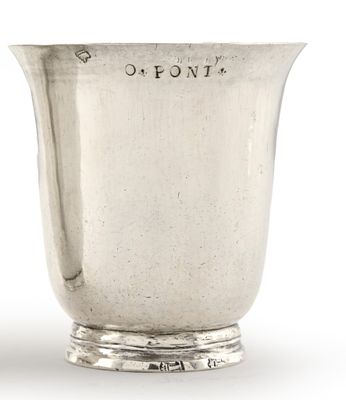 une coupe ancienne en argent posée sur un socle, sur laquelle est gravée la lettre « o »