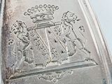 a silver spoon with a coat of arms on it