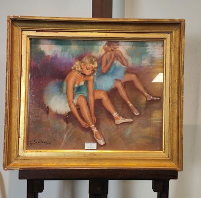 une photo d'un tableau représentant deux ballerines, posé sur un chevalet