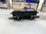 a black train car sitting on a table next to two boxes of other train cars