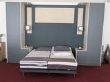 un lit avec une tête de lit intégrée dans une chambre