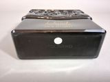 an image of a black box with a silver lid on a white surface