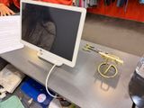 un écran d'ordinateur posé sur un bureau, avec une paire de ciseaux à côté