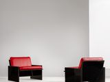 une paire de chaises noires et rouges dans une pièce blanche avec un mur blanc