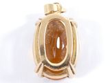 an image of a gold pendant with a brown stone in the center