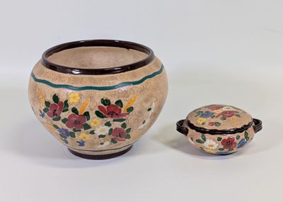 un petit vase avec un couvercle posé à côté d'un autre, plus petit