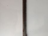 an old knife on a white surface with a piece of wood sticking out of it