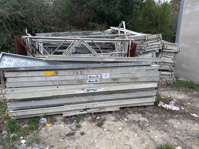 un tas de métal et de bois posé par terre devant un immeuble