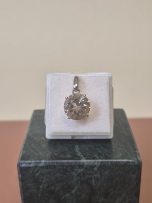 an image of a diamond pendant sitting on top of a marble block