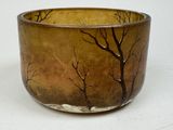 a brown bowl with trees on it sitting on a table