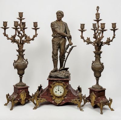 a statue of a man standing next to three candelabs