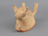 a small clay animal head on a gray surface