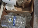 une boîte remplie de bouteilles d'eau vides et de verres vides